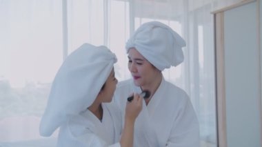 Spa konsepti 4k Çözünürlük. Kız, annesi için yatak odasında makyaj yapıyor..