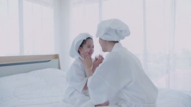 Spa konsepti 4k Çözünürlük. Annem yatak odasındaki kızına yüz maskesi takıyor..