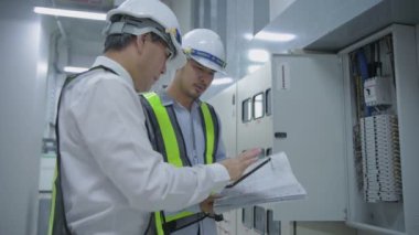 4k Kararlılığın iş konsepti. Mühendisler fabrikadaki elektrikli ekipman kontrol panellerini tamir ediyorlar..