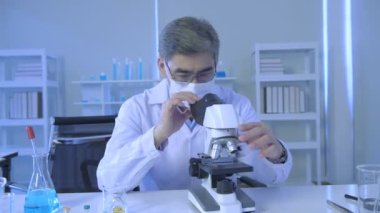 Araştırma konsepti 4K çözünürlüğü. Asyalı bilim adamları anomaliyi mikroskopla inceliyorlar..
