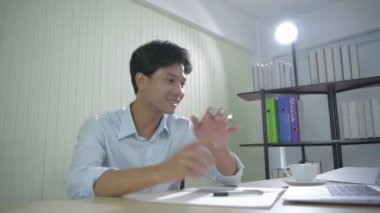 4k Kararlılığın iş konsepti. Ofiste mutlu bir Asyalı dinleniyor..