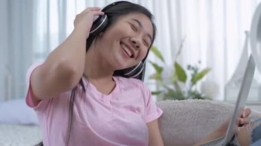 Sağlık konsepti 4k Çözünürlük. Yatak odasında bilgisayar oynayan Asyalı genç kadın..