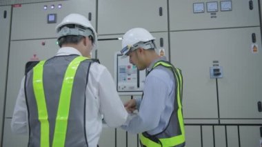 4k Kararlılığın iş konsepti. Mühendisler elektrik donanım kontrolörlerini inceliyor..