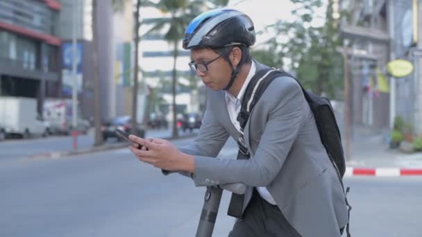 4K解像度的节能旅游车概念 亚洲男性正在使用手机探索城市通勤 — 图库视频影像