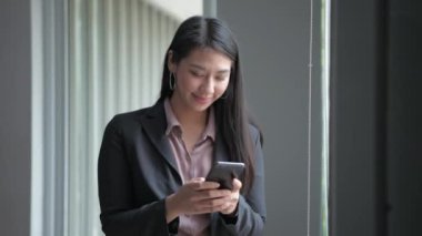 4k Kararlılığın iş konsepti. Asyalı kızlar ofisteki telefonu seve seve kullanıyorlar..