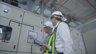 4k Kararlılığın iş konsepti. Mühendisler elektrik donanım kontrolörlerini inceliyor..