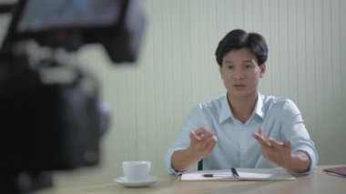 4k Kararlılığın iş konsepti. Genç Asyalı işadamı ofiste röportaj veriyor..