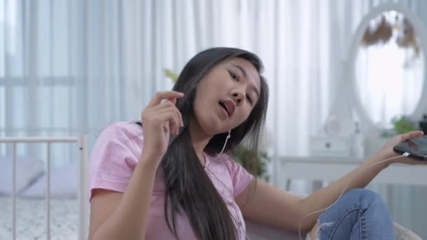 4K解像度の休日の概念 アジアの女の子楽しいですベッドルームで音楽を聴く — ストック動画