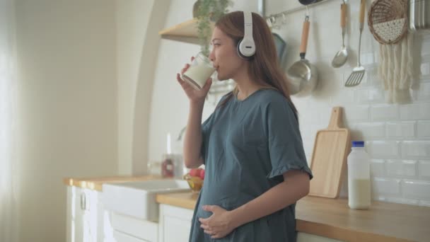 4K解像度の妊娠中の女性の概念 アジアの女の子は台所で牛乳を飲んでいます — ストック動画