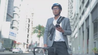 Enerji tasarruflu seyahat aracı konsepti 4k Çözünürlük. Asyalı erkekler şehir içi ulaşımı keşfetmek için cep telefonu kullanıyorlar.