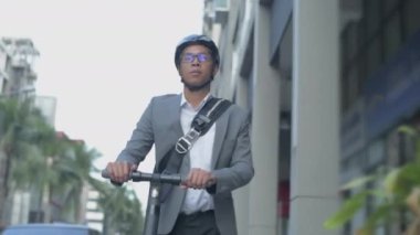Enerji tasarruflu seyahat aracı konsepti 4k Çözünürlük. Yol kenarında scooter süren Asyalı bir adam..
