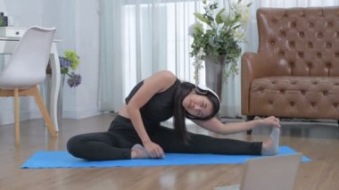 4k Çözünürlük alıştırması. Karantina sırasında spor yapan genç bir kadın. Yoga minderinde geriliyorum..