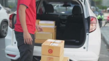 4k Kararlılığın iş konsepti. Teslimatçı paketleri arabaya yerleştiriyordu..