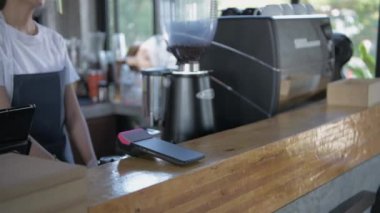 Kafe konsepti 4k Kararlılık. Çalışan ödeme makinesini taraması için müşteriye teslim ediyor..