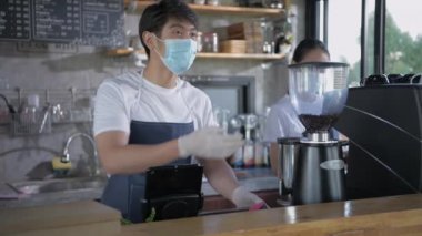 Kafe konsepti 4k Kararlılık. Çalışan ödeme makinesini taraması için müşteriye teslim ediyor..