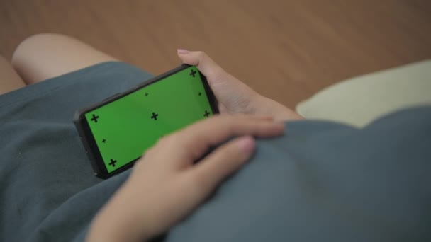 孕妇4K解析度的概念 一个女人在家里沙发上用智能手机 — 图库视频影像