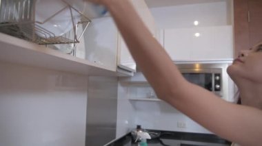 Tatil konsepti 4k Çözünürlük. Asyalı kadın mutfağı temizliyor..