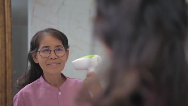 假日4K解像度的概念 亚洲老年妇女在浴室里使用吹风机 — 图库视频影像