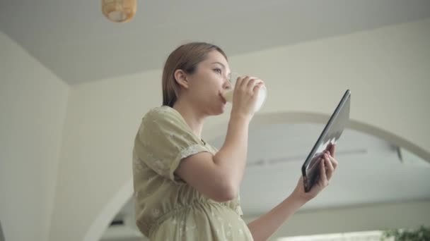 孕妇4K解析度的概念 亚洲女孩正在寻求有关怀孕护理的信息 — 图库视频影像