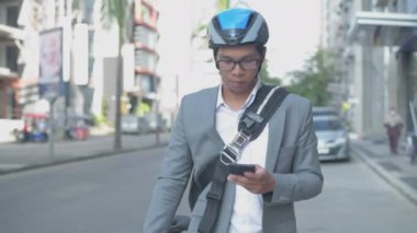 Enerji tasarruflu seyahat aracı konsepti 4k Çözünürlük. Asyalı erkekler şehir içi ulaşımı keşfetmek için cep telefonu kullanıyorlar.
