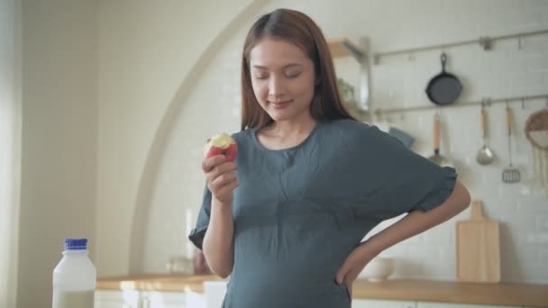 孕妇4K解析度的概念 一个孕妇在厨房里吃苹果 — 图库视频影像