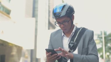 Enerji tasarruflu seyahat aracı konsepti 4k Çözünürlük. Asyalı erkekler şehir içi ulaşımı keşfetmek için cep telefonu kullanıyorlar.