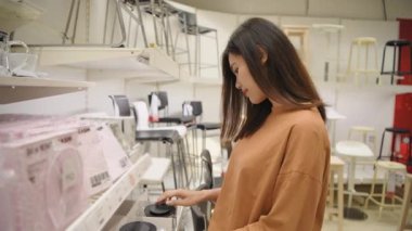 Alışveriş konsepti 4k Çözünürlük. Asyalı kadın mağazadan çaydanlık alıyor..