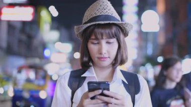 Seyahat konsepti 4k Çözünürlük. Asyalı bir kadın Çin Mahallesi 'nin manzarasının tadını çıkarırken cep telefonunu kullanıyor..