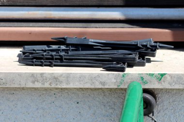 Bir grup siyah plastik bahçe hortumu bahçe sulama sisteminde plastik ve kauçuk hortumlar tutmak için kullanılır sıcak bir bahar gününde şehir bahçesinin yanındaki banliyö aile evinin mermer pencere eşiğinde bırakılır.