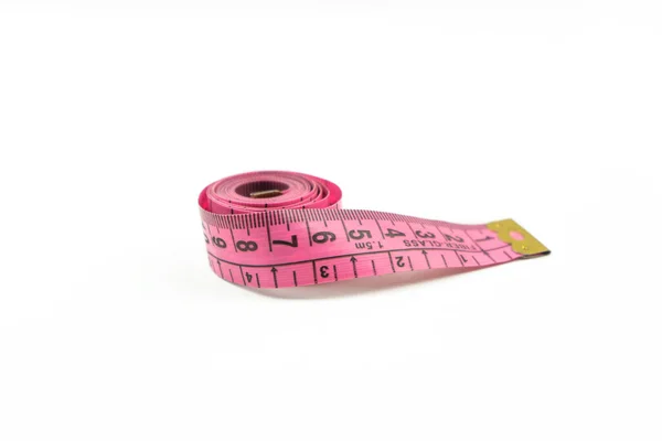 ピンクの測定テープは白いテーブルの上にあります — ストック写真