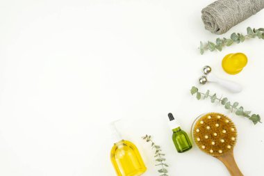 Yüz yağı ve yüz silindiri, masaj için fırça, pamuk havlu ve okaliptüs brunch 'ı.