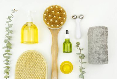 Yüz yağı ve yüz silindiri, masaj için fırça, pamuk havlu ve okaliptüs brunch 'ı.