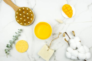 Beyaz bir sabun, bir okaliptüs dalı, bir pamuk dalı, masaj için bir fırça, beyaz bir masanın üzerinde doğal bir yağ. Vücut pozitif konsept