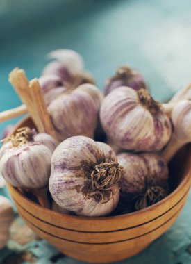 Kırsal ahşap masa üzerinde organik sarımsak karanfilleri ve ampuller, seçici odaklanma