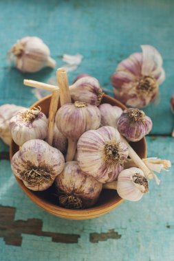 Kırsal ahşap masa üzerinde organik sarımsak karanfilleri ve ampuller, seçici odaklanma