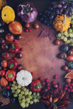 Balkabakları, üzümler, sonbahar yaprakları, olgun meyve ve sebzelerle dolu mevsimlik kompozisyon kırsal kahverengi masa üzerinde yazı, cadılar bayramı ya da şükran günü arkaplanı