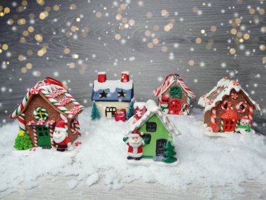 Kar ve çelenk ışıklarıyla süslenmiş kızıl bir Noel evi.