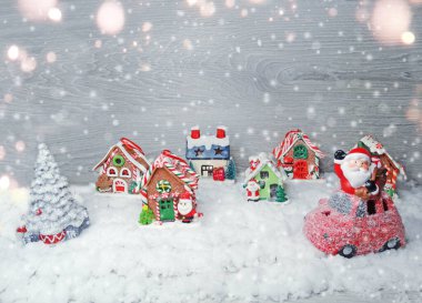 Kar ve çelenk ışıklarıyla süslenmiş kızıl bir Noel evi.