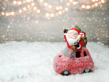 Noel Baba 'nın kırmızı araba dekorunda mavi ahşap dokuda kar var.                              