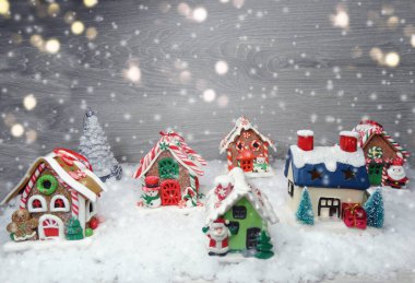 Kar ve çelenk ışıklarıyla süslenmiş kızıl bir Noel evi.