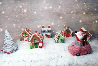 Noel Baba 'nın kırmızı araba dekorunda mavi ahşap dokuda kar var.                              