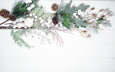 Noel arkaplanı köknar dalları koniler ve beyaz ahşap dokuda kar                              