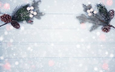 Kış Noel arkaplanı köknar dalları koniler ve mavi ahşap dokuda kar                              