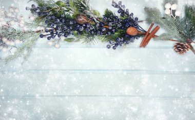 Kış Noel arkaplanı köknar dalları koniler ve mavi ahşap dokuda kar                              