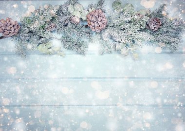 Kış Noel arkaplanı köknar dalları koniler ve mavi ahşap dokuda kar                              