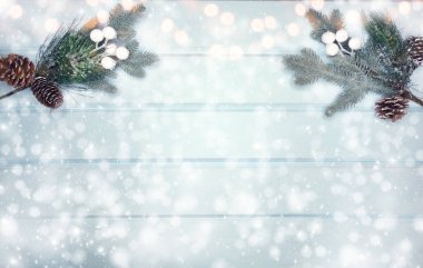 Kış Noel arkaplanı köknar dalları koniler ve mavi ahşap dokuda kar                              