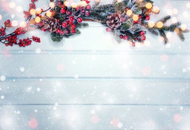 Kış Noel arkaplanı köknar dalları koniler ve mavi ahşap dokuda kar                              