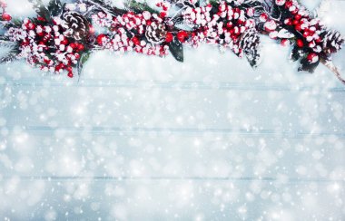 Kış Noel arkaplanı köknar dalları koniler ve mavi ahşap dokuda kar                              