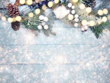 Kış Noel arkaplanı köknar dalları koniler ve mavi ahşap dokuda kar                              