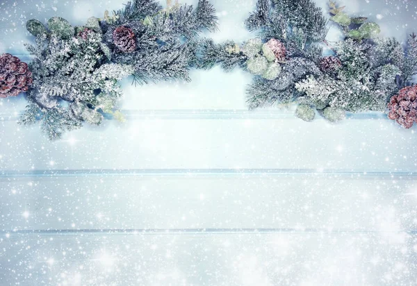 Kış Noel arkaplanı köknar dalları koniler ve mavi ahşap dokuda kar                              